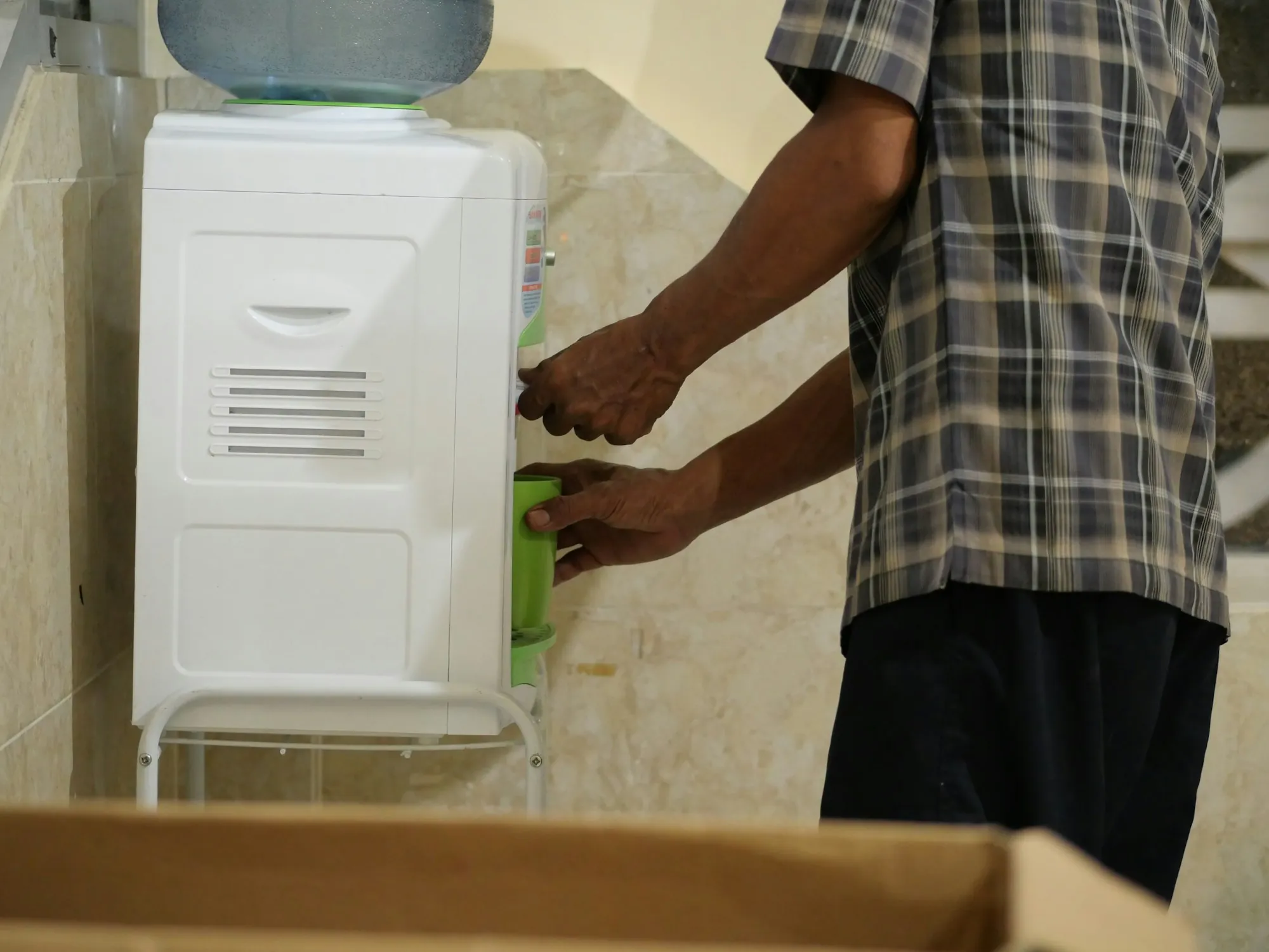 Person changing a filter on a wall-mounted water unit