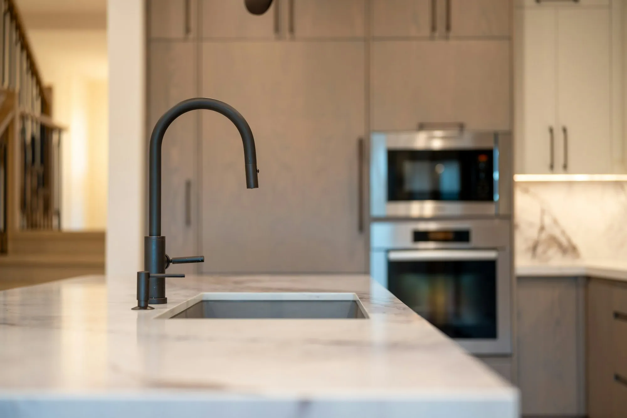Matte black faucet over a marble kitchen island