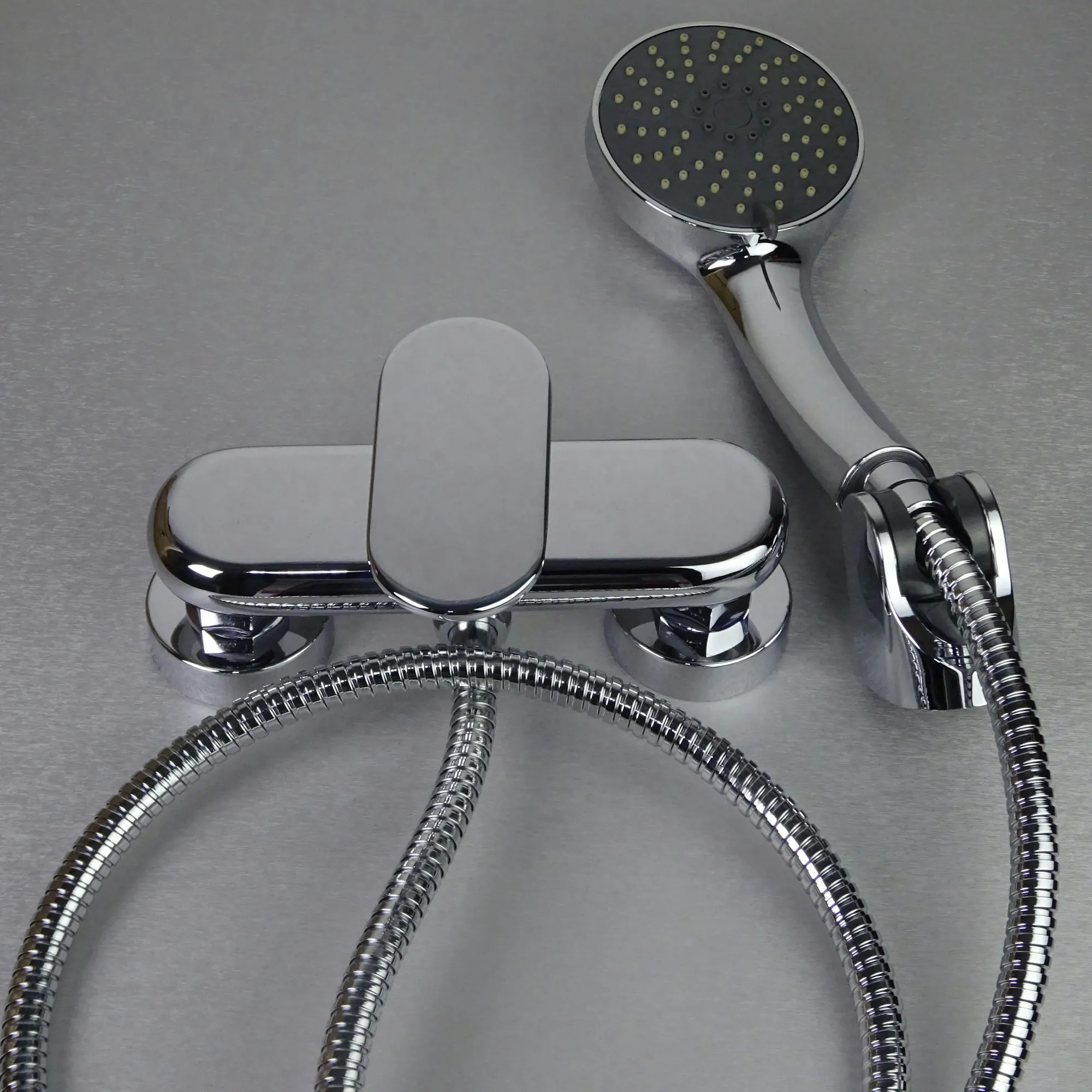 Chrome faucet and shower hose fittings on a gray surface