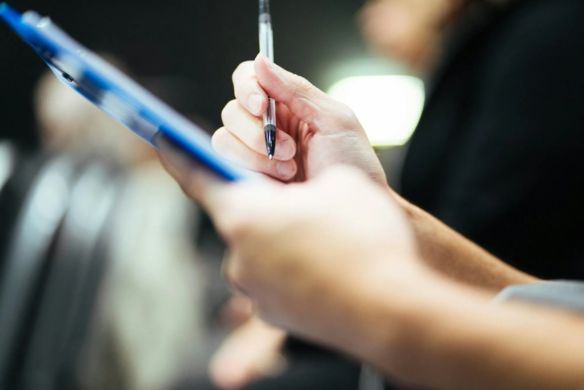 Hand taking notes on a tablet during a home visit