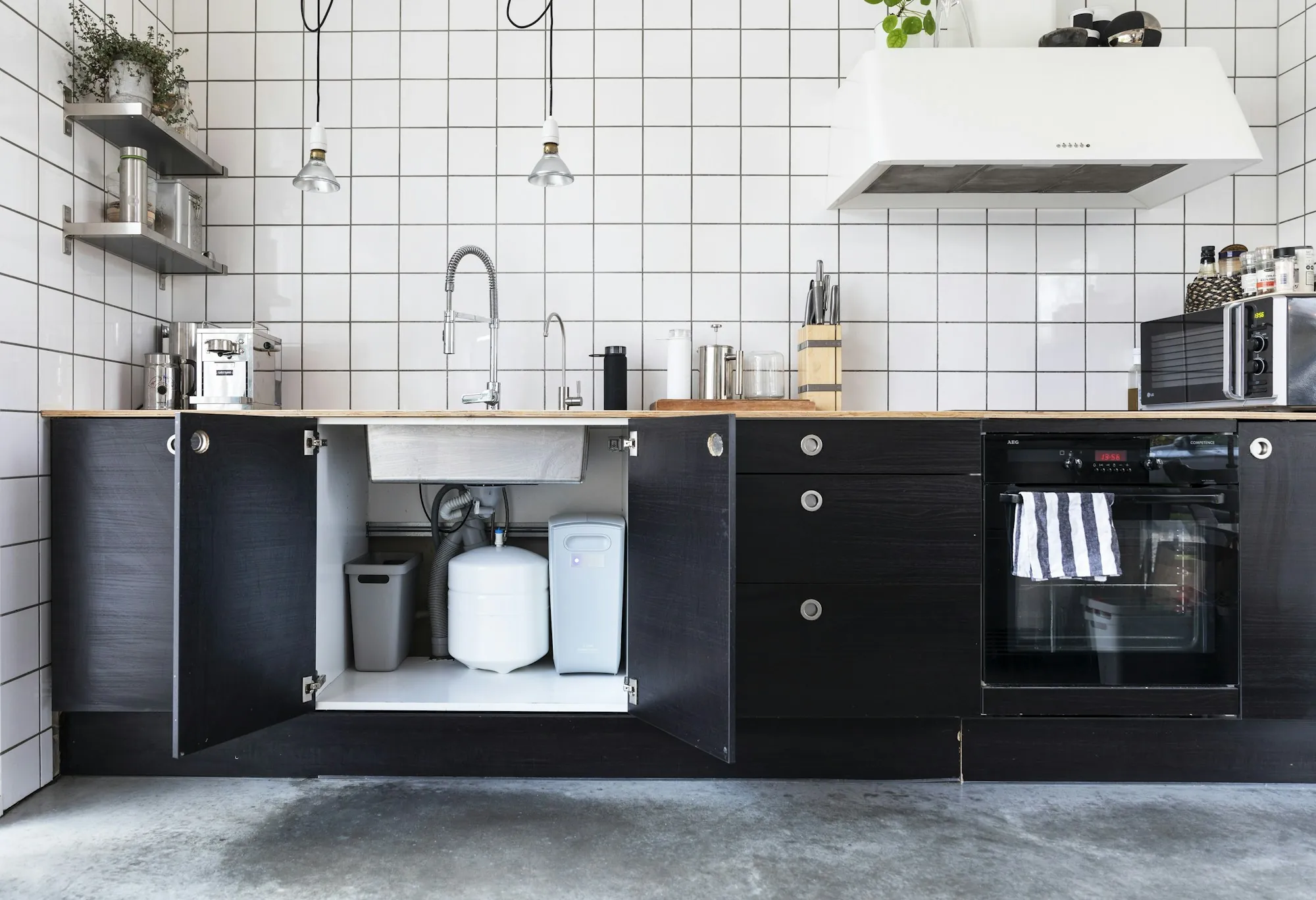 Open kitchen cabinet with a filtration unit under the sink